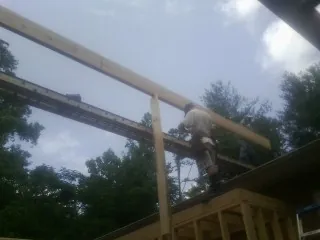 Carpenter setting a ridge beam over a new addition frame — Ice Dam Removal by Roofing Brothers in Challis