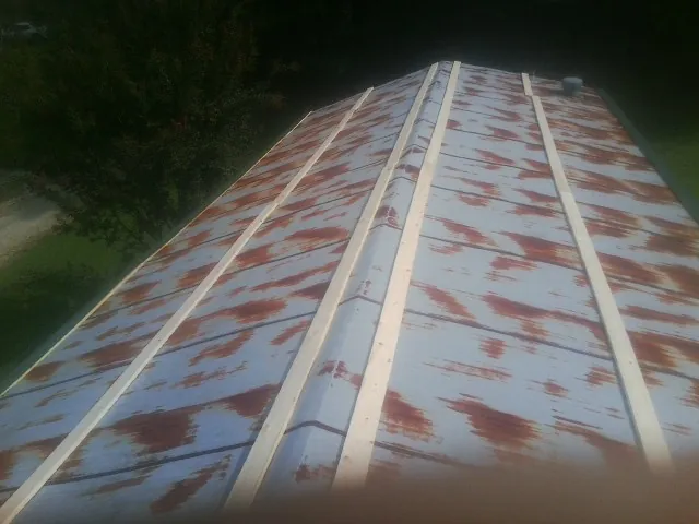 Rusted metal roof panels with new wood purlins before replacement — Storm Damage Roof Repair in Challis by Roofing Brothers