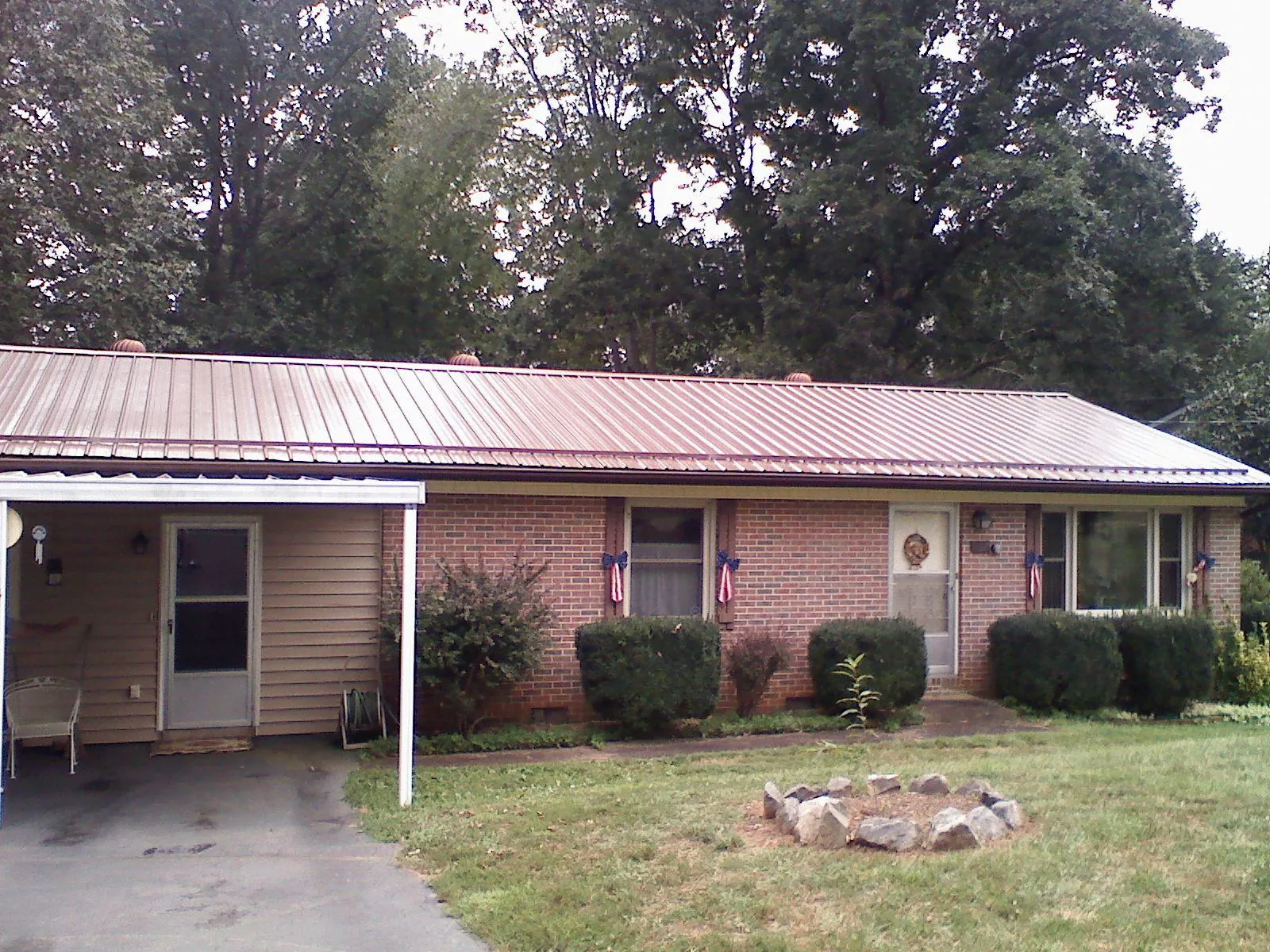 Bronze metal roof and carport on a brick ranch home — Roof Repair work by our crew in Challis